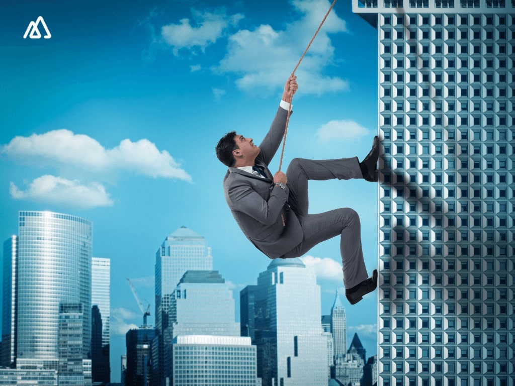 man on a rope climbing on a building